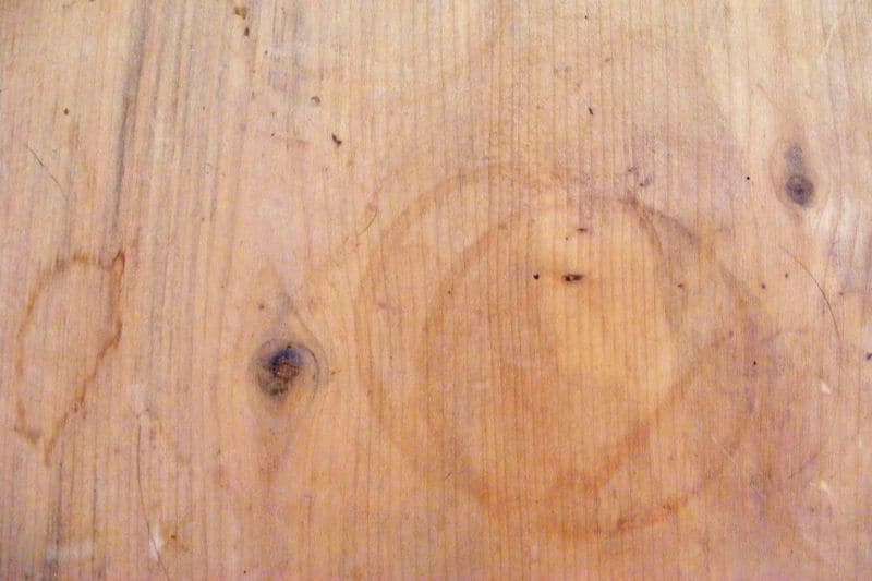 Anillos de agua en la mesa de centro de madera que no se ha terminado