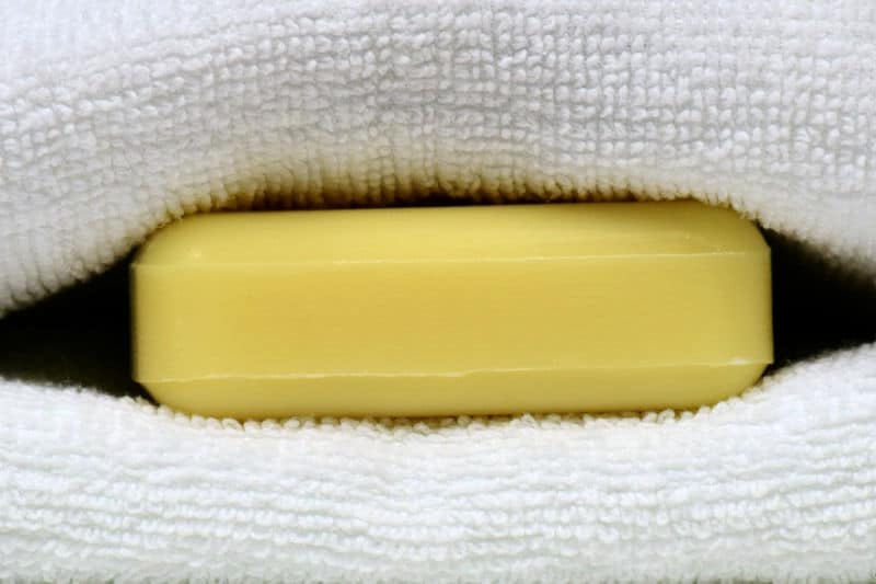 Cómo organizar los armarios para ropa blanca: una barra de jabón metida entre las toallas dobladas