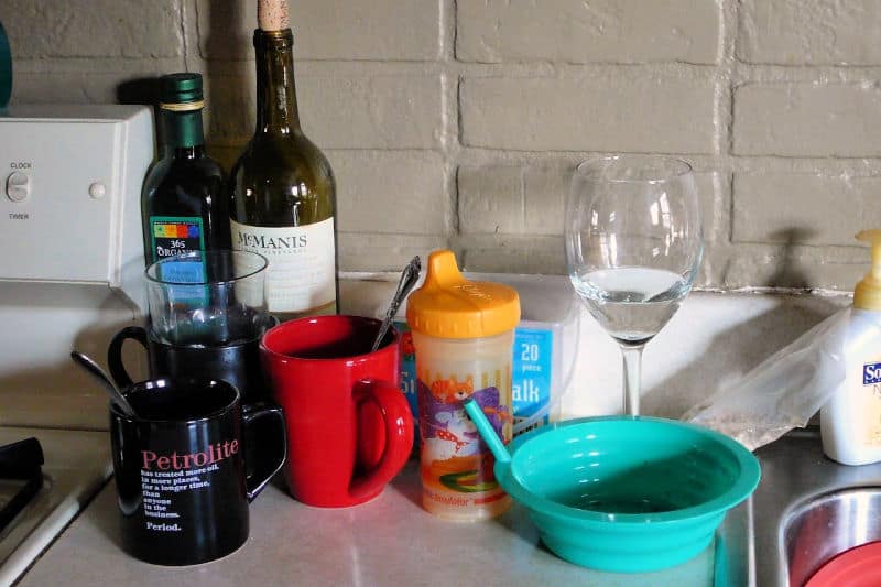 Platos sucios y una botella de vino en la cocina